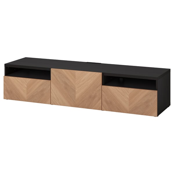 Czarno-drewniana szafka pod telewizor ikea BESTÅ z trzema szufladami. Blat jest, a szuflady mają wzór drewna w jodełkę.