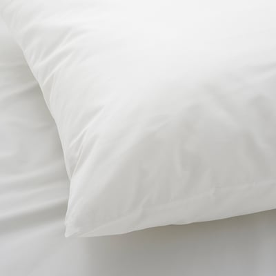 Biała poszewka na nieskazitelnie białą pościel, prezentująca gładką, wysokiej jakości bawełnianą fakturę.