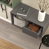 Ścienny EKET z ubraniami i książką.