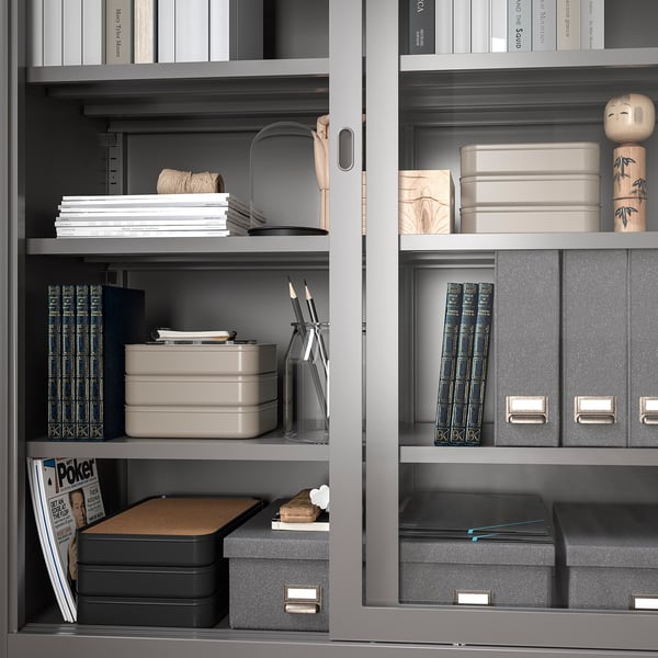 Uporządkowane półki z szarymi pudełkami HARVMATTA, schludnie przechowujące dokumenty i artykuły biurowe.