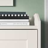 Biały komoda HAUGA z książkami, minimalistyczny design.