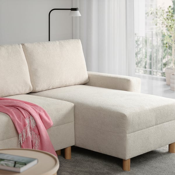 JÄRINGSHOLM sofa – kompaktowa, jasna, nowoczesny design z miejscami do przechowywania, wieloosobowa, różowa narzuta.