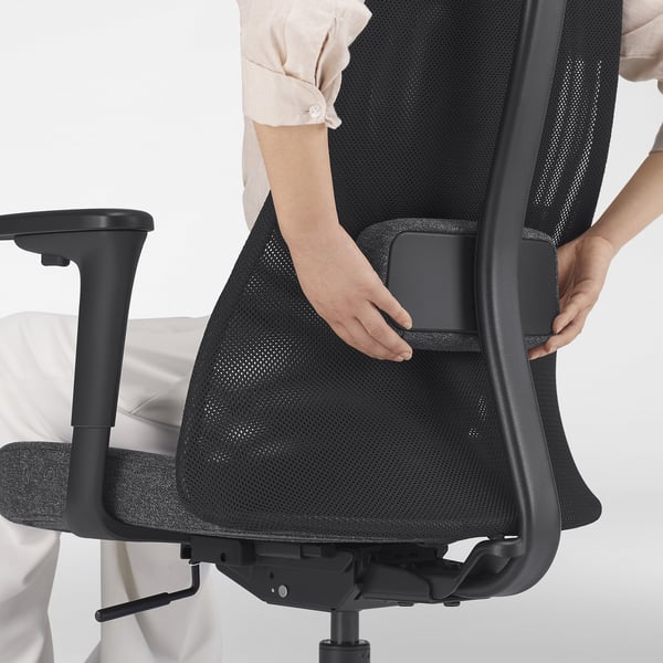 Regulowane podparcie lędźwiowe: pokazane ręce dostosowują podparcie oparcia na ergonomicznym krześle biurowym.