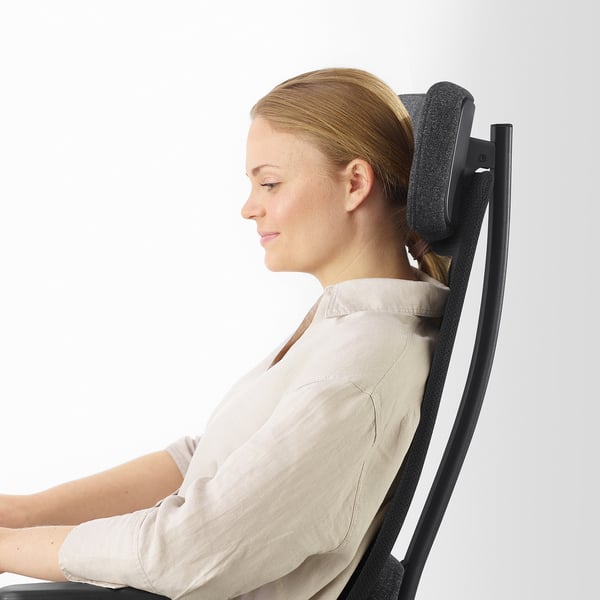 Kobieta siedzi na krześle biurowym JÄRVFJÄLLET, demonstrując ergonomiczne podparcie i regulację odcinka lędźwiowego.