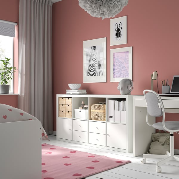 Biały schowek IKEA KALLAX w sypialni, poziomy z szufladami i otwartymi przestrzeniami, otoczony wystrojem.