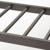 Nowoczesny metalowy wieszak na spodnie o eleganckim, ciemnym wykończeniu. Solidne drążki zapewniają trwałość i łatwy dostęp do spodni.