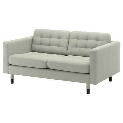 Jasnozielona sofa LANDSKRONA z wyściełanymi siedziskami i oparciami, drewnianymi nogami i nowoczesnym designem.