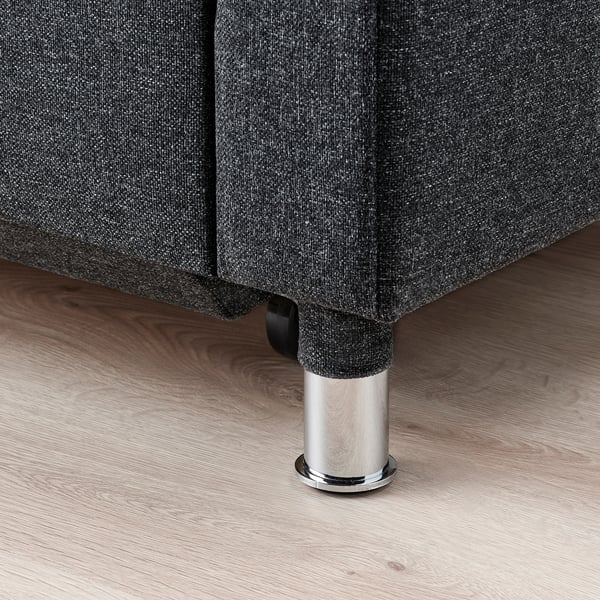 Sofa z ciemnej tkaniny z chromowanymi nogami, solidny i nowoczesny design.