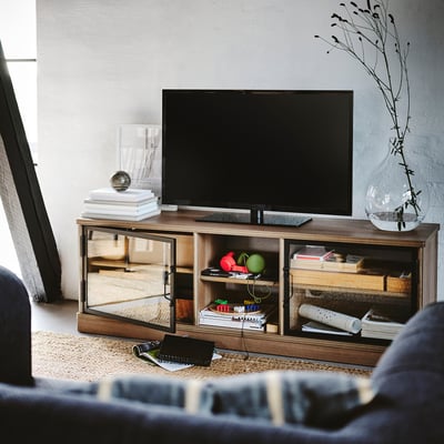 Nowoczesny salon z szafką pod telewizor LANESUND, telewizorem z płaskim ekranem i niebieską kanapą.