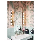 Lustro z oświetleniem led, umywalką i zieloną ścianą wyłożoną kafelkami.