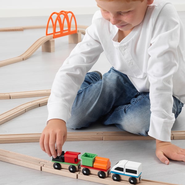 Dziecko bawi się torami kolejowymi LILLABO i kolorowymi wagonkami.