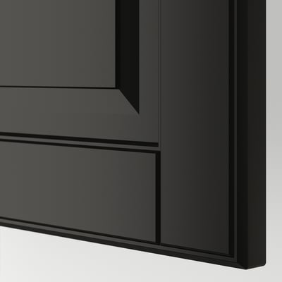 Zbliżenie na czarną szafkę kuchenną z gładkimi, ściętymi krawędziami. Nowoczesny design z czystymi liniami i solidną konstrukcją.