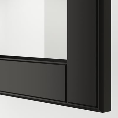 Drzwi szklane w czarnej ramie ze ściętymi krawędziami, będące częścią nowoczesnego systemu kuchennego, oferujące elegancki i wyrafinowany design.