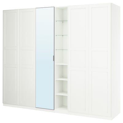 Biała szafa PAX z lustrzanymi drzwiami i otwartymi półkami. Minimalistyczny design i dużo miejsca do przechowywania.