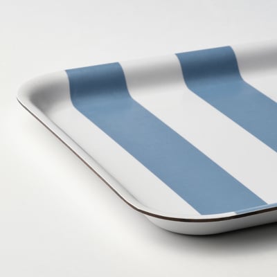 Prostokątna taca w biało-niebieskie paski wykonana z wysokociśnieniowego laminatu melaminowego.