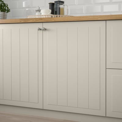 Składa się z beżowych drzwi szafki STENSUND z pionowymi rowkami. Ma gładką, lakierowaną powierzchnię i prostokątny kształt.