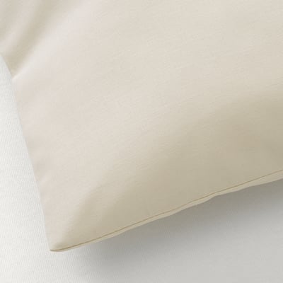 Zbliżenie na gładką, kremową tkaninę. Tekstura wydaje się miękka i drobno tkana, co wskazuje na wysoką jakość i trwałość.