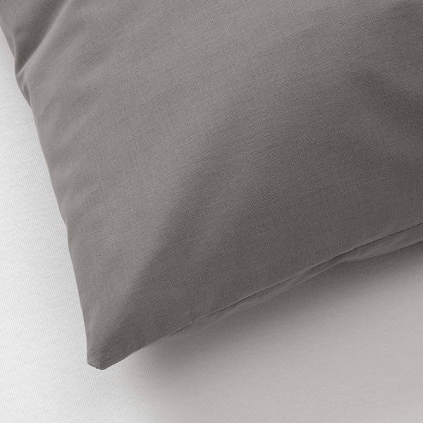 Zbliżenie na miękką, szarą bawełnianą poszewkę na poduszkę, eksponującą jej gładką fakturę i delikatny splot.