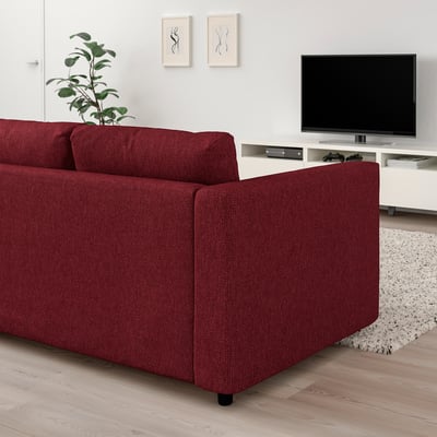 Czerwona sofa VIMLE w salonie z telewizorem i rośliną.