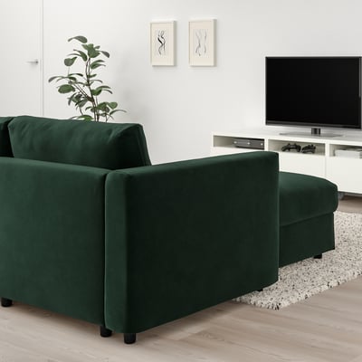 Ciemnozielona rozkładana sofa VIMLE, stylowa, w kształcie litery L, o nowoczesnym designie, idealnie pasuje do przestrzeni mieszkalnej, z telewizorem i rośliną.