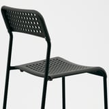 Black modern stackable chair, perforated seat and backrest, sturdy metal frame.