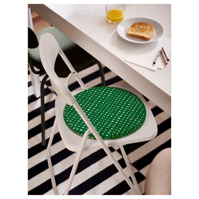 A round, green recycled polyester chair pad with a white checkered pattern, designed for comfortable seating.