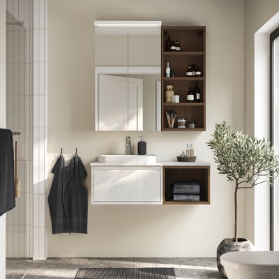 Modern minimalist bathroom with ÄNGSJÖN vanity, marble top, open wood storage, large mirror cabinet, towels, and plant.