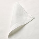 Crisp, white, folded organic cotton sheet showcasing fine stitching, exuding quality and elegance.