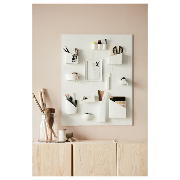 Home office with light wood storage, white organizer, office supplies, and a vase of pencils.