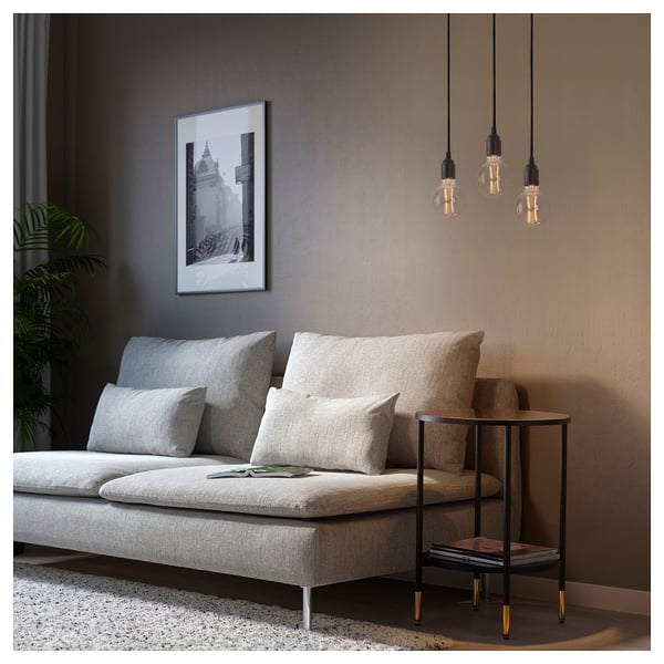 Modern living room with grey BENGTSBOL pendant lamp, beige sofa, cushions, black side table, plant, and framed art.