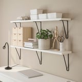 Shelves with black brackets, boxes, papers, plant, and laptop below.
