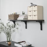 Wall-mounted shelf displaying storage boxes, wicker basket, books, and decorative items.