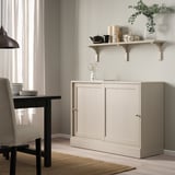 BERGSHULT shelf in light beige with varied decor, medium size.