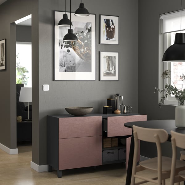 Modern living room with grey walls, featuring pink & grey BESTÅ storage, metal decor, and black pendant lights.