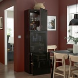 Modern dining room with black storage, glassware, and mugs, against burgundy wall.