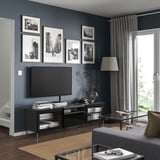 Modern grey living room with BESTÅ tv bench, photos, rug, coffee table, and sofa.