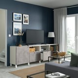 Modern living room with smart tv stand, soft-close drawers, and adjustable shelves. Dark blue walls, framed art, curtains, and cozy couch.