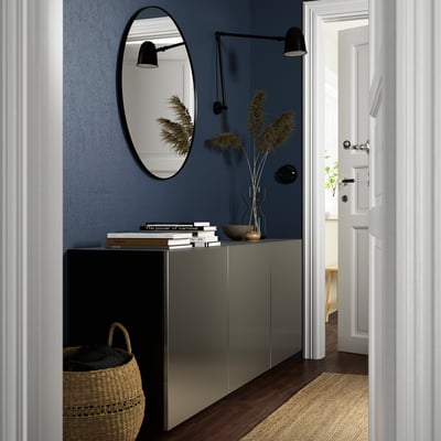 Modern entrance: BESTÅ grey cabinet, dark blue wall, mirror, books, vase, basket.