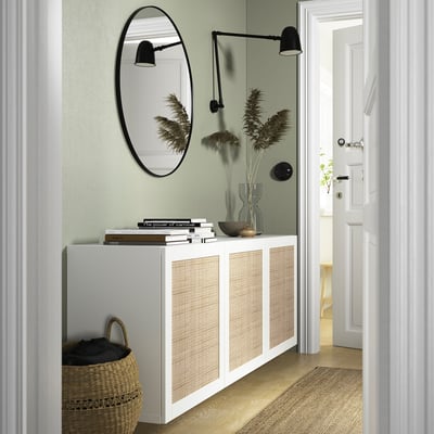 Modern entryway: BESTÅ white console, round mirror, black lights, dried plants, books, woven basket.