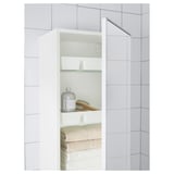 Open vanity unit with folded towels, soap, brush, and lotion.