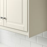 White kitchen cabinet with chrome knobs and tiled backsplash, used to cover lighting and cords.