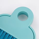 Small, light blue brush with pet plastic bristles and polypropylene handle, designed for desk cleaning.