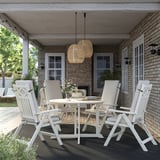 Outdoor dining set with acacia furniture, pendant lights, and cushions on patio.