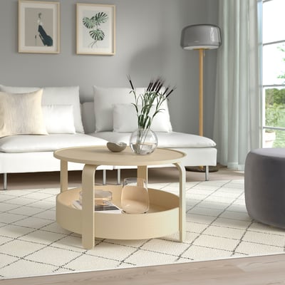 Living room with BORGEBY round table, rug, sofa, ottoman, lamp, art.