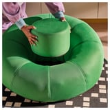 Inflating BRÄNNBOLL chair with pump on rug.