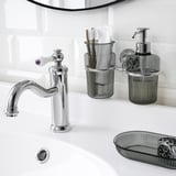 Chrome-plated sink faucet with gleaming finish, accompanied by matching soap dispenser and toothbrush holder on wall, all part of brofjäreden series.