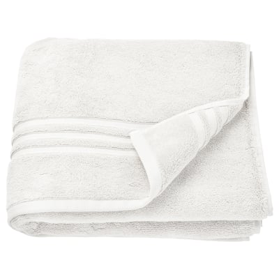This image shows BROKGLIM towels, white, folded neatly. Made of 100% organic cotton, featured with a woven border.
