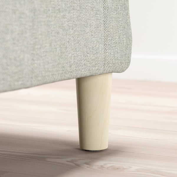 Leg of upholstered furniture, cylindrical wooden support, light-colored wood.