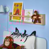 Kids room with DJUNGELSKOG monkey toy, zebra pillow, and artwork on shelf.