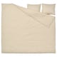 A beige DOFTAKLEJA duvet cover with check and stripe patterns, featuring corner holes for easy duvet insertion.